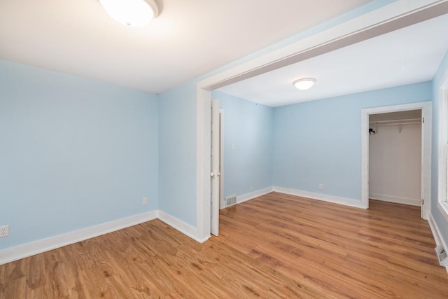 unfurnished bedroom with a closet and light wood-type flooring