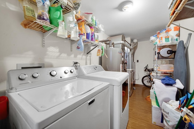 clothes washing area with washer and clothes dryer, light wood-type flooring, and gas water heater