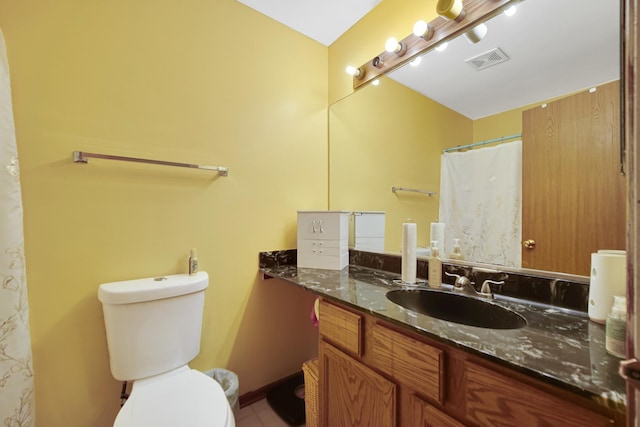 bathroom featuring toilet, tile patterned floors, and vanity