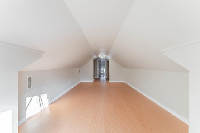 additional living space with vaulted ceiling and hardwood / wood-style floors