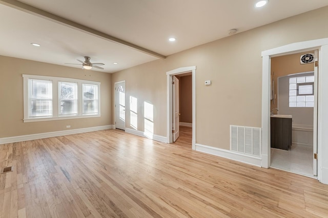 empty room with ceiling fan, light hardwood / wood-style floors, and a healthy amount of sunlight