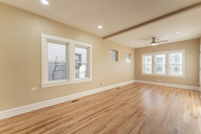 empty room with ceiling fan, light hardwood / wood-style floors, and beam ceiling