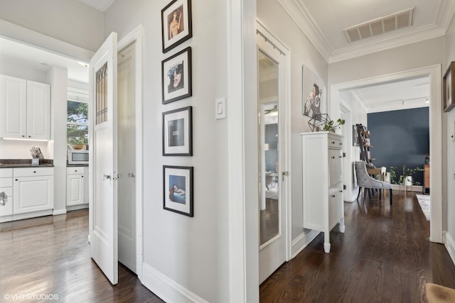 corridor with ornamental molding and dark hardwood / wood-style floors