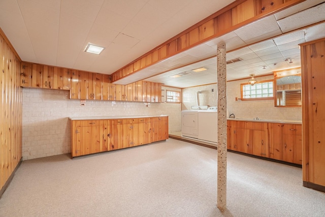 kitchen with washing machine and clothes dryer, plenty of natural light, and light carpet