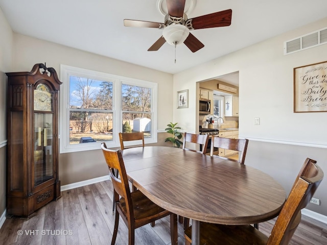 dining space featuring sink, ceiling fan, and hardwood / wood-style floors