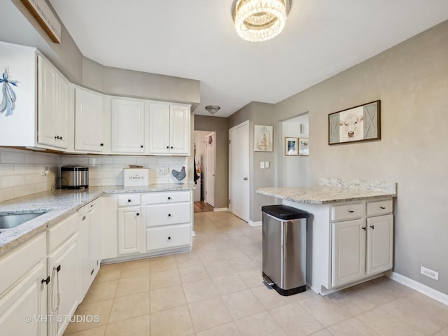 kitchen featuring light tile patterned flooring, white cabinetry, decorative backsplash, and light stone countertops