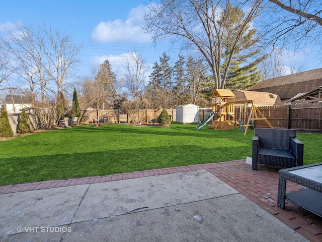 view of yard with an outdoor living space, a patio, a storage shed, and a playground