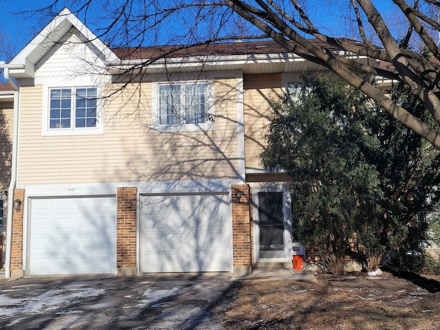 view of front of home featuring brick siding, driveway, and an attached garage