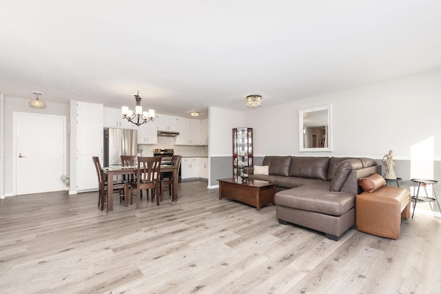 living room featuring a notable chandelier and light hardwood / wood-style floors