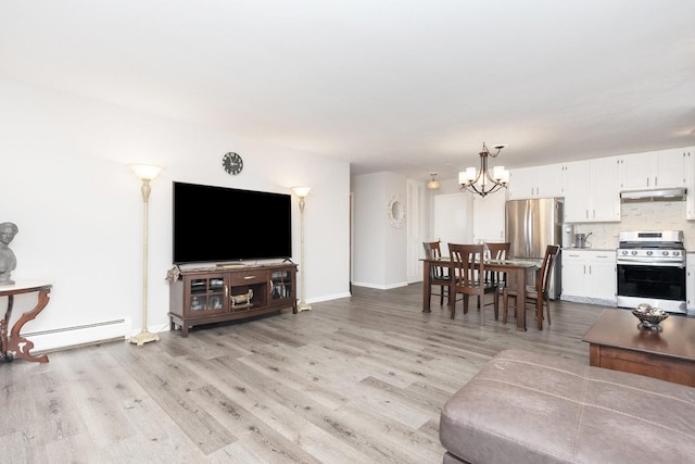 living room featuring an inviting chandelier, baseboard heating, and light hardwood / wood-style flooring