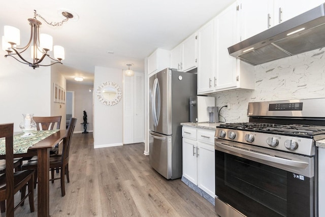 kitchen with light stone countertops, pendant lighting, an inviting chandelier, white cabinets, and appliances with stainless steel finishes