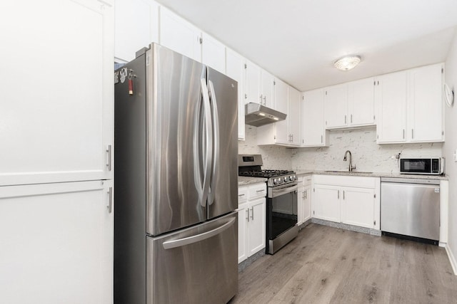 kitchen with sink, white cabinets, light hardwood / wood-style floors, and appliances with stainless steel finishes