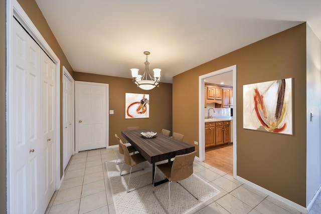 tiled dining room with sink and a notable chandelier