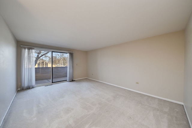 empty room with visible vents, light colored carpet, and baseboards