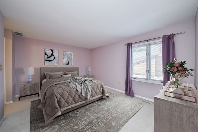 bedroom featuring visible vents, baseboards, and light carpet