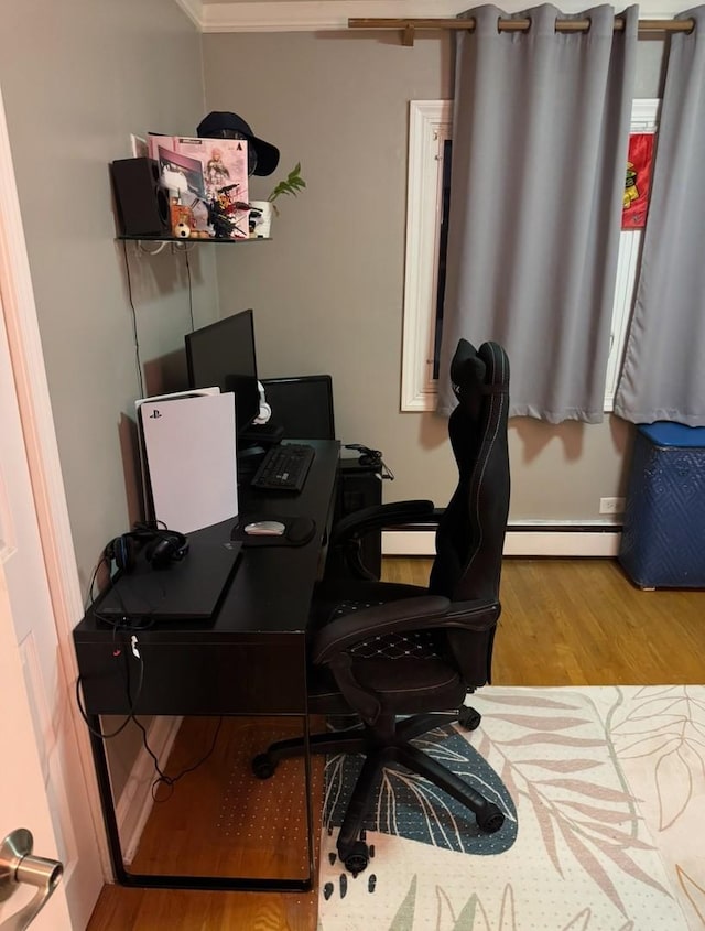 office with ornamental molding, light hardwood / wood-style floors, and a baseboard radiator