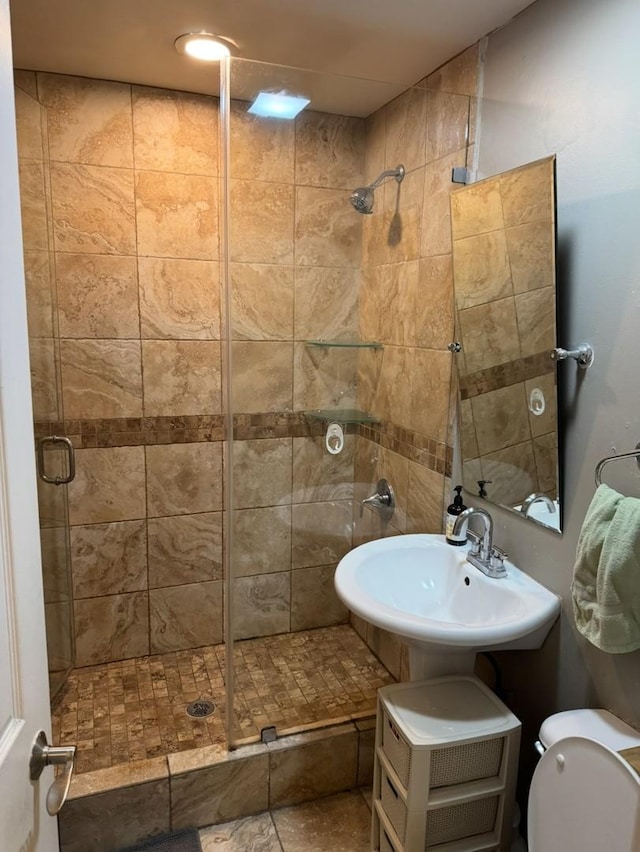 bathroom featuring sink, an enclosed shower, and toilet