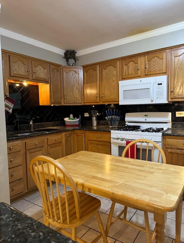 kitchen with sink, white appliances, light tile patterned flooring, tasteful backsplash, and crown molding