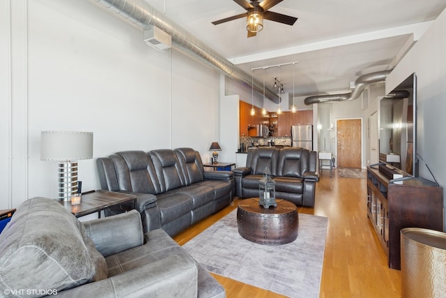 living room featuring ceiling fan, rail lighting, and light wood-type flooring