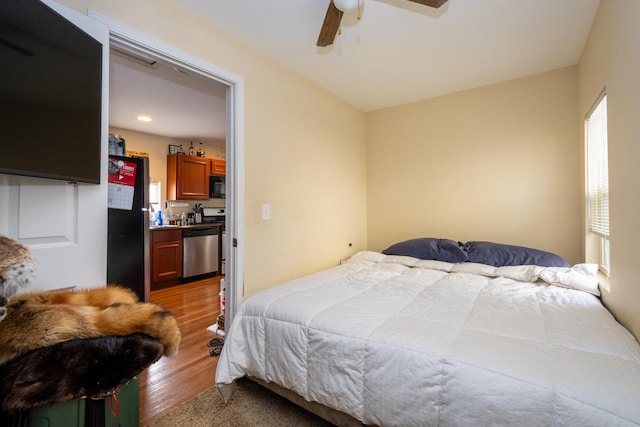 bedroom featuring ceiling fan, stainless steel fridge, and light hardwood / wood-style floors