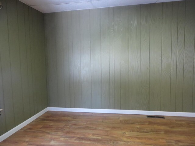 empty room with dark hardwood / wood-style floors and crown molding