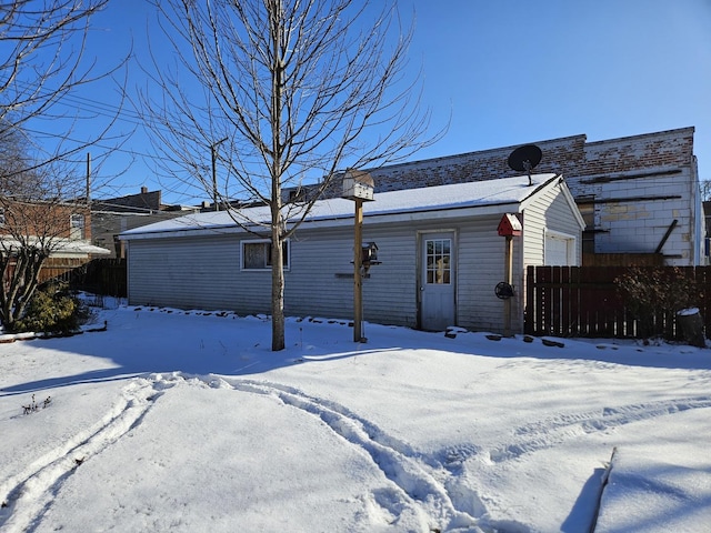 view of snow covered back of property