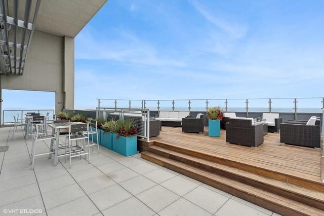 wooden deck featuring a water view, a patio area, and an outdoor living space