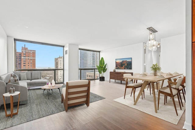 living room with a chandelier, light hardwood / wood-style floors, and expansive windows