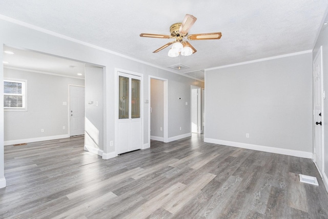 empty room with a textured ceiling, ceiling fan, crown molding, and wood-type flooring