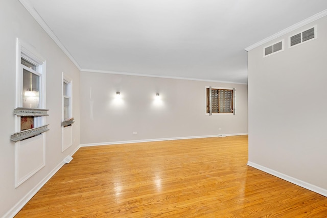 empty room featuring light hardwood / wood-style floors and crown molding