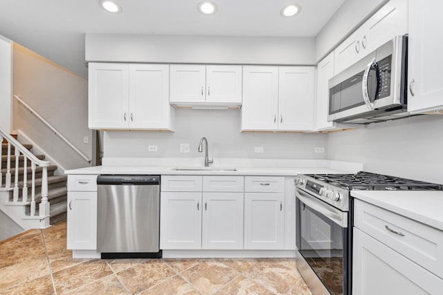 kitchen with sink, appliances with stainless steel finishes, and white cabinetry