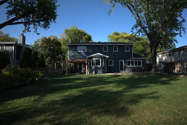 rear view of house with a yard and a pergola