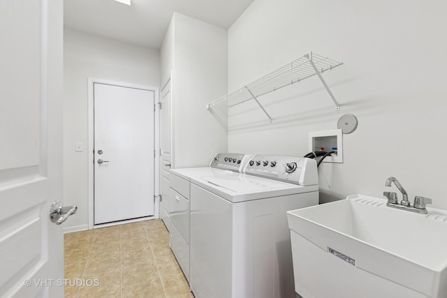 clothes washing area featuring sink, light tile patterned floors, and washing machine and clothes dryer