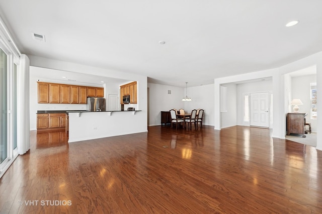 unfurnished living room with a healthy amount of sunlight and dark hardwood / wood-style floors