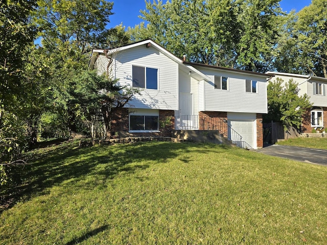 raised ranch featuring a garage and a front yard