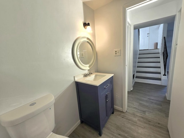 bathroom featuring vanity, hardwood / wood-style flooring, and toilet