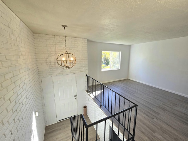 foyer entrance featuring dark hardwood / wood-style floors, a textured ceiling, and a notable chandelier