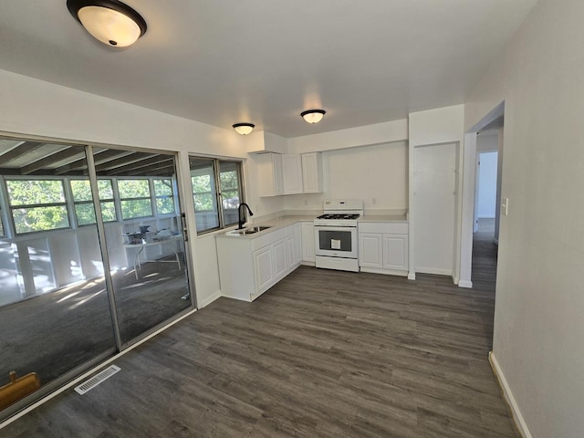 kitchen featuring white cabinetry, sink, dark hardwood / wood-style floors, and white gas range oven