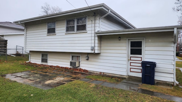 back of house with central air condition unit and a lawn