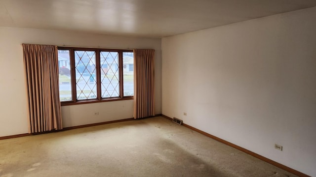 unfurnished room featuring light colored carpet