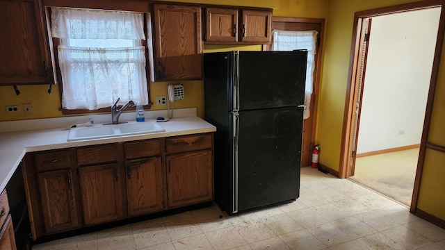 kitchen featuring black fridge and sink