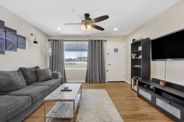 living room with ceiling fan and light hardwood / wood-style flooring