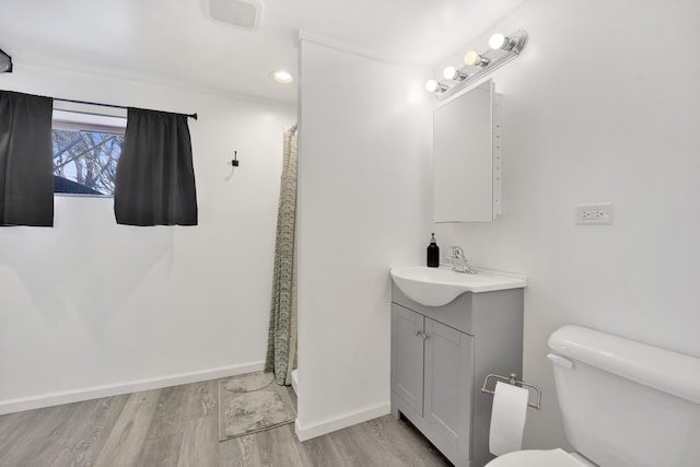 bathroom with toilet, vanity, hardwood / wood-style floors, and walk in shower