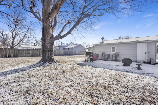 yard covered in snow with a fire pit