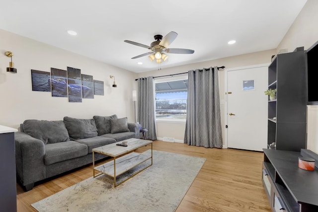 living room with light wood-type flooring and ceiling fan