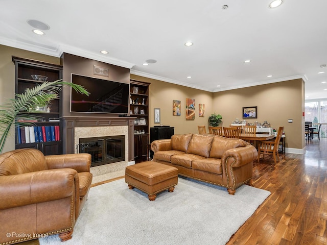 living room with hardwood / wood-style flooring, a high end fireplace, and ornamental molding