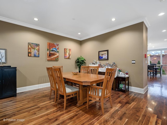 dining area with dark wood-type flooring and crown molding