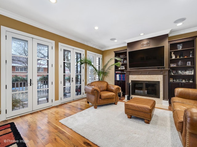 living room featuring hardwood / wood-style floors, ornamental molding, and french doors