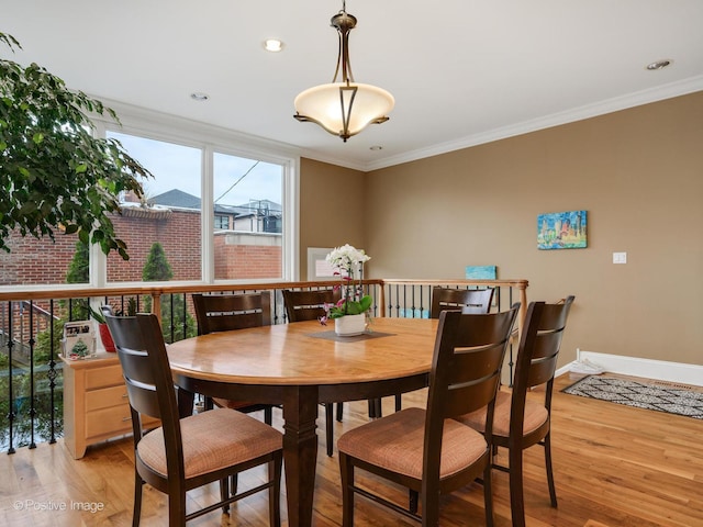 dining space featuring ornamental molding and light hardwood / wood-style floors