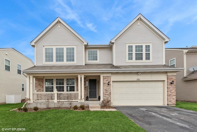 view of front of home with a garage, a front lawn, and covered porch